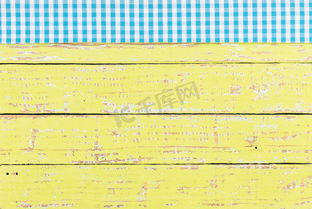 厨房桌面背景摄影照片_黄色木桌面背景纹理，带有质朴的蓝色桌布