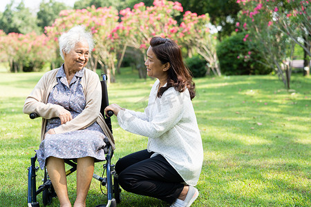 照顾者帮助和照顾亚洲老年妇女在愉快的新鲜假期中在公园散步时使用健康强壮的助行器。