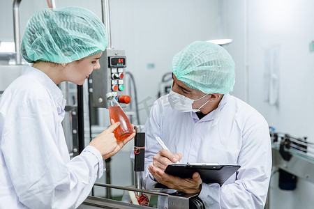 质量控制和食品安全团队检查食品和饮料工厂生产线的产品标准。