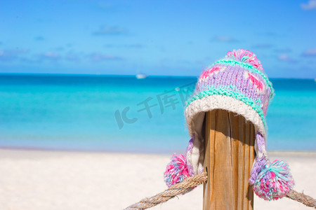 天空围栏摄影照片_热带海滩围栏上的特写温暖针织帽