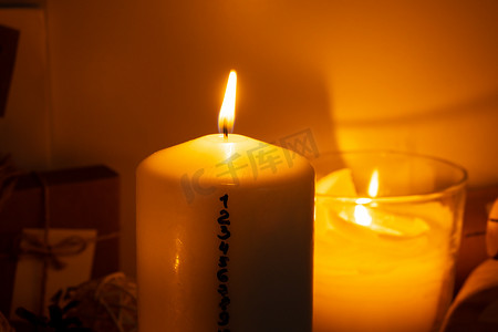 日历倒计时摄影照片_带有降临节日历的蜡烛 传统燃烧的圣诞蜡蜡烛，带有圣诞节倒计时数字。