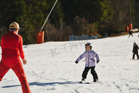 儿童滑雪摄影照片_滑雪教练给孩子上课