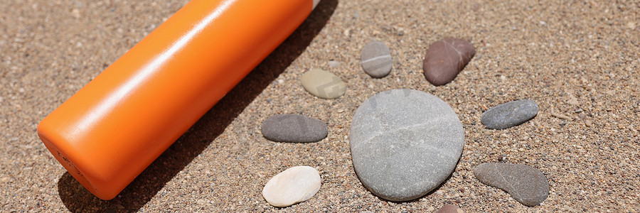 海砂橙色液体瓶霜或乳液上用石头制成的太阳