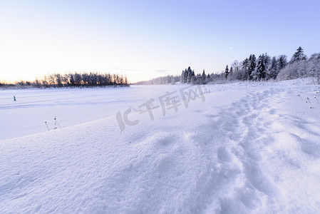 冻脚摄影照片_冰湖和森林覆盖着大雪和漂亮的蓝光