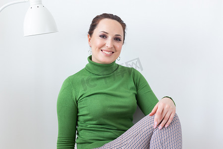 快乐生活摄影照片_快乐情绪的女人在家里客厅的椅子上放松 — 单身女性和快乐生活的概念