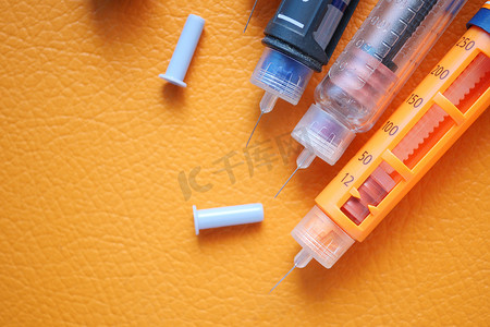 医务室背景摄影照片_橙色背景中的胰岛素笔