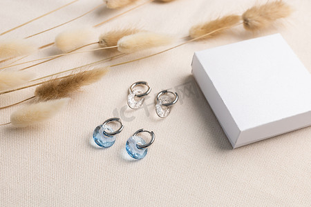 银耳环摄影照片_优雅的珠宝套装银耳环与宝石和礼品盒模拟复制空间。