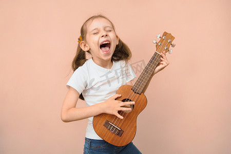 小学年龄段情绪化的白人女孩用四弦琴和自己一起唱歌