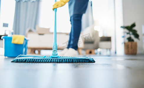 家务、清洁和女佣用拖把清洁房子的客厅地板。