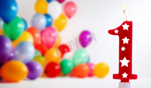 1 号生日庆祝蜡烛在明亮的白色背景下与彩色气球，为一岁的孩子点燃派对蜡烛。
