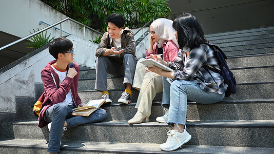 大学生交谈摄影照片_一群大学生课后坐在楼梯上互相交谈。