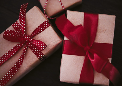 圣诞礼物和传统节日礼物，木制背景的经典圣诞礼盒，用红丝带工艺纸包裹的礼物，复古乡村风格的季节性假期