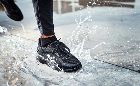 脚在街上溅水，人在雨中奔跑，鞋子在西雅图路的水坑里进行户外有氧运动。
