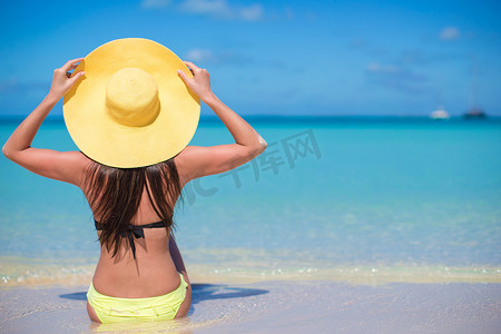 沙滩上戴帽子的年轻时尚女性