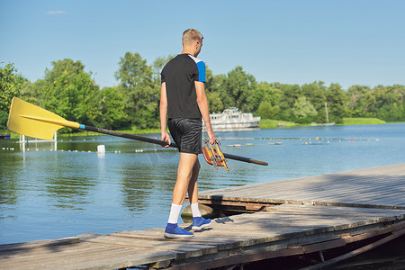 运动会幕布摄影照片_带桨的少年男孩骑运动皮划艇