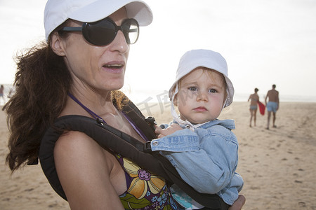 背着背包的妈妈和宝宝在海滩