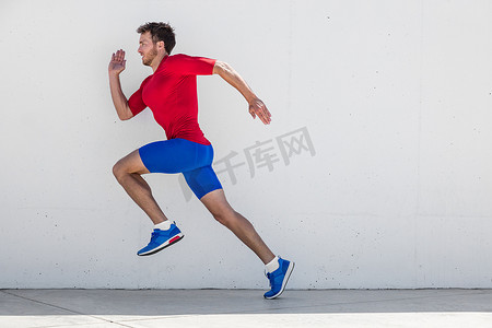 跑步男子跑步训练做户外城市跑步沿着墙壁背景冲刺。