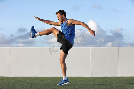 跑步者准备跑步做热身动态腿部伸展运动，男运动员在夏季户外跑步前拉伸下半身腿筋肌肉。