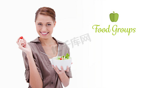 食物团体反对女人用手指拿着一碗沙拉和小西红柿