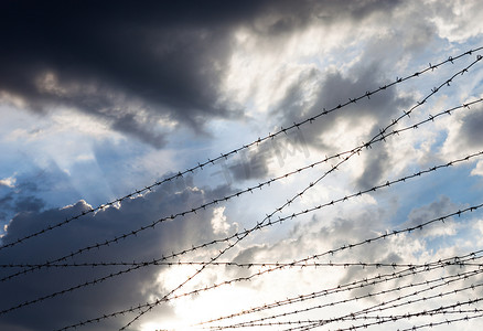 天空围栏摄影照片_多云天空背景下的铁丝网