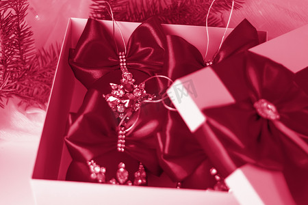 2023喜庆摄影照片_一份圣诞礼物，在浅色背景上用冷杉树枝装饰着美丽的蝴蝶结。