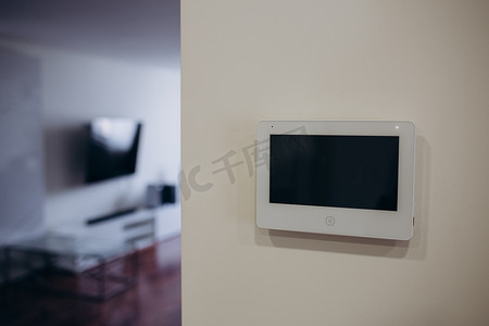 现代客厅墙上挂着智能家居应用程序的智能屏幕