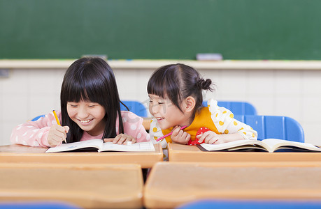 可爱的小学生看她的同学作业