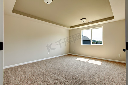 有米黄地毯的新的空的室。