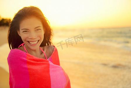 沙滩女孩开心地笑着裹着毛巾