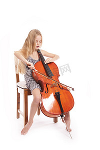 演奏大提琴的穿裙子的年轻女孩
