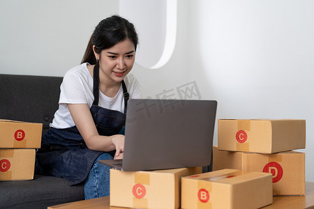 小型企业创业公司、中小企业主、女企业家处理包裹箱收据并在线检查订单以准备箱子。