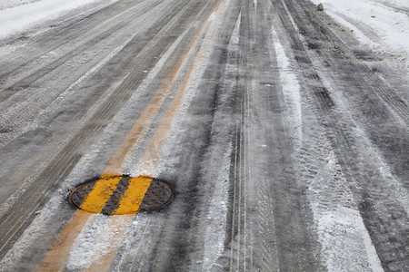 冬天街道摄影照片_有黄线的湿滑的结冰的路