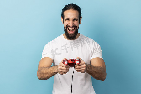 男子手持红色游戏手柄操纵杆，以乐观的表情看着相机，享受游戏。