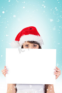 女性红色海报摄影照片_漂亮的圣诞老人女孩拿着海报对着镜头微笑