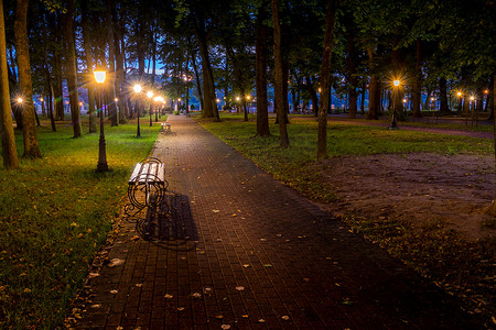 一个夜间公园，灯笼点亮，铺着石头，树木，瀑布
