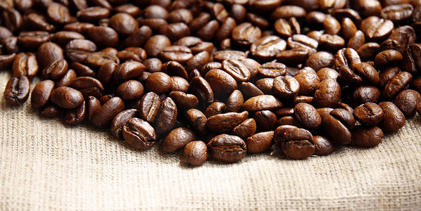 咖啡豆纹理摄影照片_织物特写上咖啡豆的背景