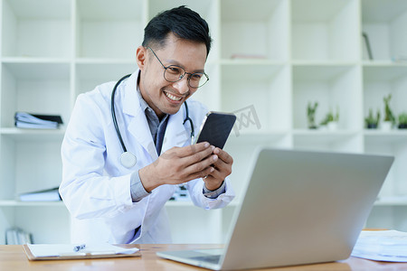 医生在工作中使用智能手机和计算机治疗疾病前查看患者信息的肖像