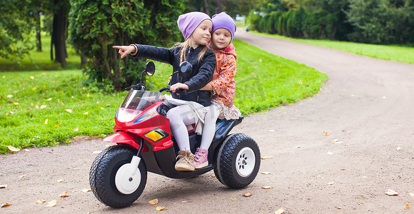 快乐的小可爱女孩在外面骑摩托车