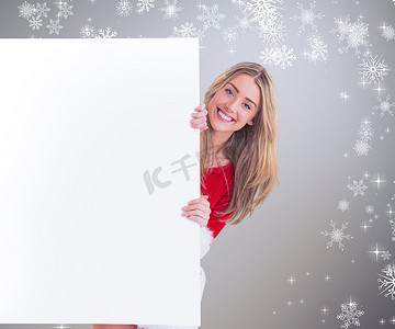 漂亮的圣诞老人女孩在海报后面对着相机微笑的合成图像
