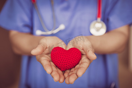 医生护士手给红心以帮助护理或献血医疗保健分享爱来对抗疾病的概念。