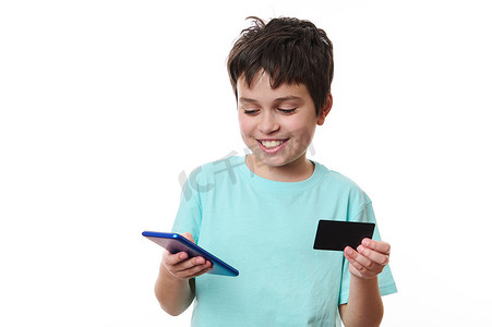 使用手机和信用卡的英俊微笑的白人男学生在网上购物时进行无现金支付