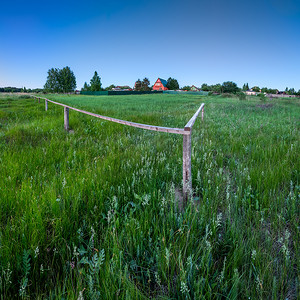 黄昏的村庄摄影照片_M 附近传统俄罗斯村庄的红房子和木栅栏