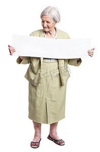 女八十年代摄影照片_微笑的老太太手里拿着白纸