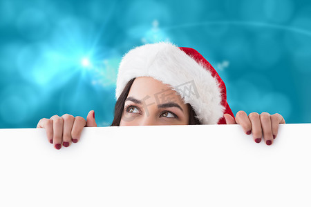 冬天海报摄影照片_戴着圣诞帽的漂亮黑发女郎的合成图像显示白色海报