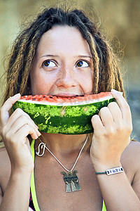 吃女孩西瓜摄影照片_Dreadlock gils 吃一块西瓜