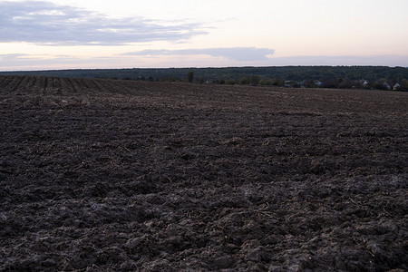 夕阳下田野上刚耕过的黑色肥沃土壤。