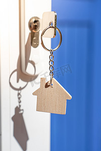 用钥匙和家居形状的钥匙扣打开通往新家的门。