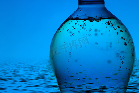矿泉水瓶摄影照片_蓝色背景中的矿泉水瓶