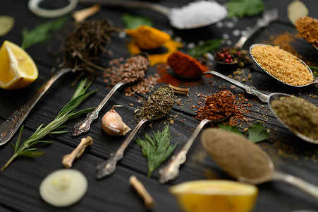 食物香料摄影照片_在深色木质乡村背景下烹饪的五颜六色的各种香草和香料