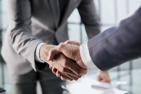 两个商人的握手，他们签订了开发新软件以改善公司业务服务的合同。